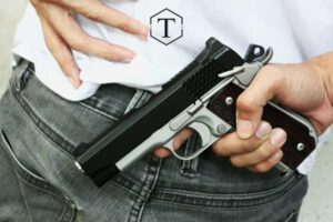 man holding handgun behind his back